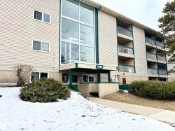 The property features a multi-story building with a light-colored exterior and green trim - 