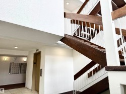 The building features a well-maintained staircase with dark wood and white railings, complemented by an elevator for convenience - 