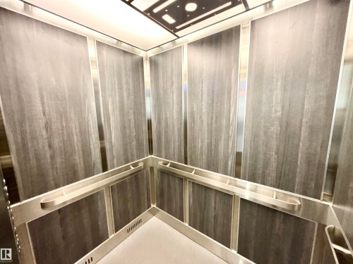 The property features a contemporary elevator with wood paneling and sleek silver accents - 307 1620 48 Street, Edmonton, AB - Indoor Photo Showing Other Room