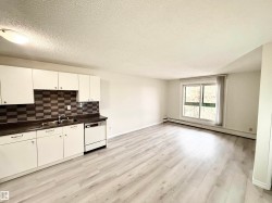 Open concept living area featuring light-toned flooring, white walls, and a large window providing natural light - 