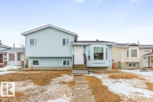 The property features light blue siding, a bay window, and a pathway leading to the front door - 3132 49A Street, Edmonton, AB - Outdoor