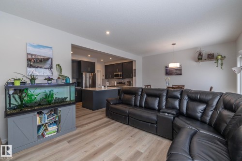 The open concept living area features light-toned flooring, recessed lighting, and sightlines to the kitchen and dining areas - 159 Larch Crescent, Leduc, AB - Indoor Photo Showing Living Room