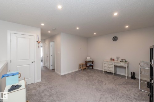 This spacious room features neutral-toned carpet, recessed lighting, and white walls - 159 Larch Crescent, Leduc, AB - Indoor