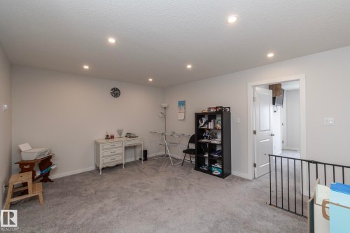 This versatile room features light grey walls and light grey carpeting, creating a neutral canvas - 159 Larch Crescent, Leduc, AB - Indoor