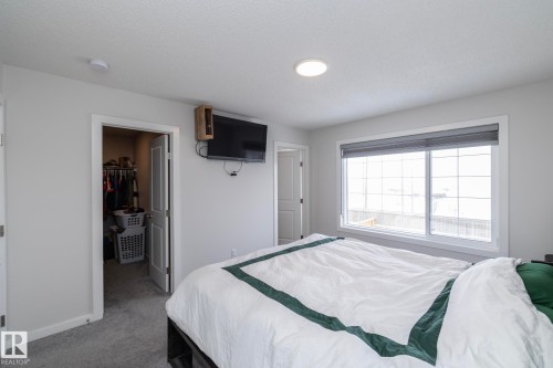 This room features a window with a roller shade, light gray walls, and carpeting - 159 Larch Crescent, Leduc, AB - Indoor Photo Showing Bedroom