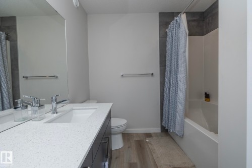 The bathroom features a modern vanity with a white countertop and an integrated rectangular sink - 159 Larch Crescent, Leduc, AB - Indoor Photo Showing Bathroom