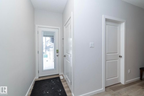 Entryway featuring light-colored walls, a glass-paneled door, and wood-look flooring - 159 Larch Crescent, Leduc, AB - Indoor Photo Showing Other Room