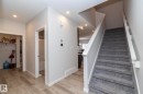 The entryway features light wood-style flooring, a staircase with gray carpeting and white railings, and recessed lighting - 159 Larch Crescent, Leduc, AB  - Indoor Photo Showing Other Room 