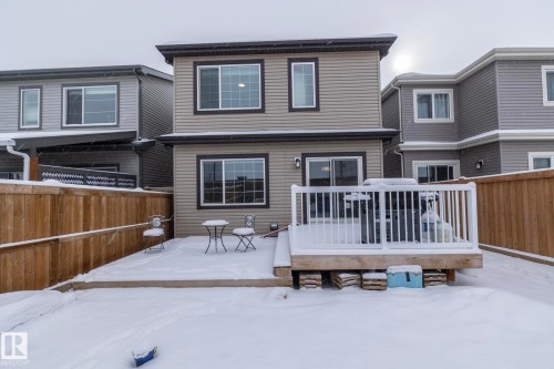The property features a two-story exterior with light-colored horizontal siding and dark trim around the windows - 159 Larch Crescent, Leduc, AB - Outdoor With Deck Patio Veranda