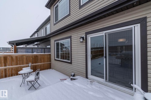 The property features an exterior with light-colored horizontal siding and dark trim - 159 Larch Crescent, Leduc, AB - Outdoor With Deck Patio Veranda With Exterior