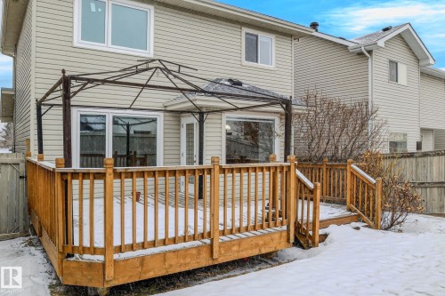 The property features a wooden deck with railing, accessible via sliding glass doors - 978 Rutherford Road Sw, Edmonton, AB - Outdoor With Exterior