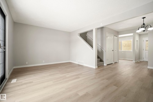 Spacious living area featuring light-toned flooring, neutral paint, and white trim - 3311 139 Avenue, Edmonton, AB - Indoor Photo Showing Other Room
