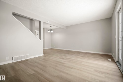 This spacious room features light-toned flooring and neutral walls, providing a versatile foundation for various design preferences - 3311 139 Avenue, Edmonton, AB - Indoor Photo Showing Other Room