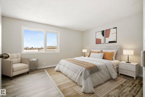 This inviting bedroom features light-colored walls, a large window, and light wood-style flooring - 3311 139 Avenue, Edmonton, AB - Indoor Photo Showing Bedroom