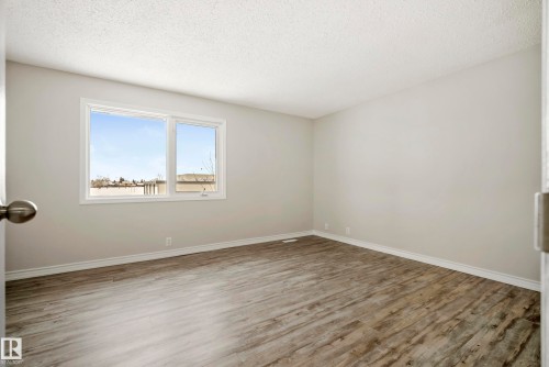 This room features light-colored walls, wood-style flooring, and a window that provides natural light - 3311 139 Avenue, Edmonton, AB - Indoor Photo Showing Other Room
