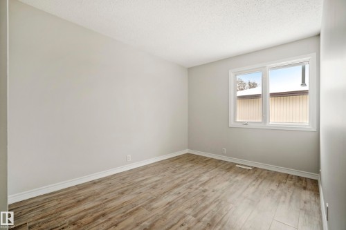This room features hardwood flooring, light-colored walls, and a window providing natural light - 3311 139 Avenue, Edmonton, AB - Indoor Photo Showing Other Room
