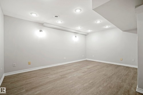Spacious room with recessed lighting and light-toned flooring, featuring neutral wall paint and white baseboards - 3311 139 Avenue, Edmonton, AB - Indoor Photo Showing Other Room