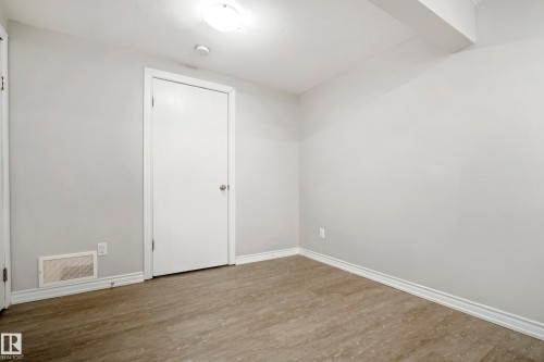 This room features light grey walls, light-toned wood-look flooring, and a white ceiling with an overhead light fixture - 3311 139 Avenue, Edmonton, AB - Indoor Photo Showing Other Room