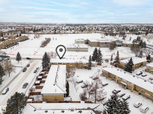 Aerial view showcasing the property's proximity to an expansive snow-covered field and a large building with a distinctive architectural style - 3311 139 Avenue, Edmonton, AB - Outdoor With View