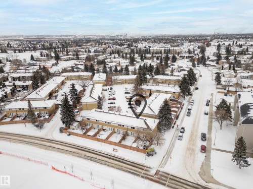 Aerial view of the property and surrounding neighborhood, featuring a large parking area and established trees - 3311 139 Avenue, Edmonton, AB - Outdoor With View