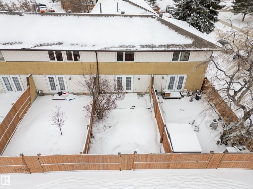 The property features a private fenced yard accessible through double patio doors, providing an outdoor space with a small tree - 3311 139 Avenue, Edmonton, AB - Outdoor