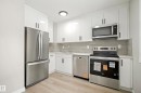 The kitchen features white cabinetry, stainless steel appliances, light countertops, and a light-colored backsplash - 3311 139 Avenue, Edmonton, AB  - Indoor Photo Showing Kitchen With Stainless Steel Kitchen 