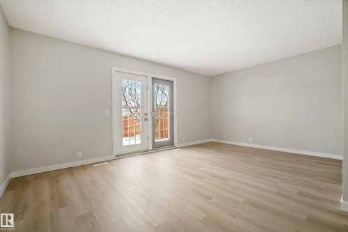 This bright and spacious room features light-colored walls and modern wood-look flooring - 3311 139 Avenue, Edmonton, AB - Indoor Photo Showing Other Room