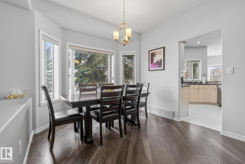 Dining area featuring dark wood flooring, a bay window, and a chandelier - 17204 113 Street, Edmonton, AB - Indoor Photo Showing Dining Room