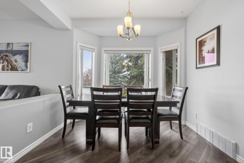 This dining area features large bay windows providing ample natural light and views of mature trees - 17204 113 Street, Edmonton, AB - Indoor Photo Showing Dining Room