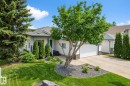 The property features a well-maintained lawn, mature trees, and landscaping with stone accents - 17204 113 Street, Edmonton, AB  - Outdoor 