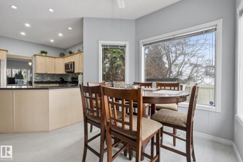 Dining area with large windows, light grey walls, and a light-colored flooring - 17204 113 Street, Edmonton, AB - Indoor Photo Showing Dining Room