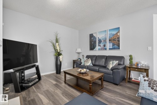 Living area featuring light grey walls, dark wood-style flooring, and white trim - 17204 113 Street, Edmonton, AB - Indoor Photo Showing Living Room