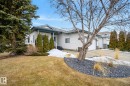The property features a white exterior with a dark-colored roof and trim, a front porch with white railings, and a double garage - 17204 113 Street, Edmonton, AB  - Outdoor 
