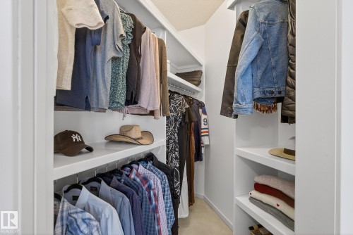 The property features a walk-in closet with white built-in shelving, clothing rods, and an overhead light fixture - 17204 113 Street, Edmonton, AB - Indoor With Storage
