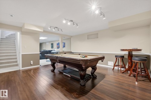Spacious recreational area featuring hardwood floors, a billiards table, and a high-top table with stools - 17204 113 Street, Edmonton, AB - Indoor Photo Showing Other Room