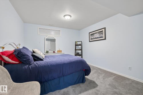 This room features light blue walls, gray carpeting, and a ceiling-mounted light fixture - 17204 113 Street, Edmonton, AB - Indoor Photo Showing Bedroom