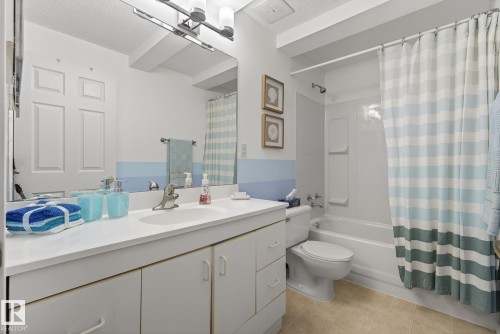 Well-appointed bathroom featuring a vanity with storage, a large mirror, a toilet, and a bathtub with a shower - 17204 113 Street, Edmonton, AB - Indoor Photo Showing Bathroom