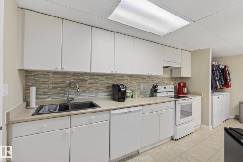 The property features a kitchen with white cabinetry, a double basin sink, and a tiled backsplash - 17204 113 Street, Edmonton, AB - Indoor Photo Showing Kitchen With Double Sink