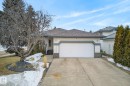 The property features a concrete driveway, an attached garage, and a light-colored exterior with stone accents - 17204 113 Street, Edmonton, AB  - Outdoor 