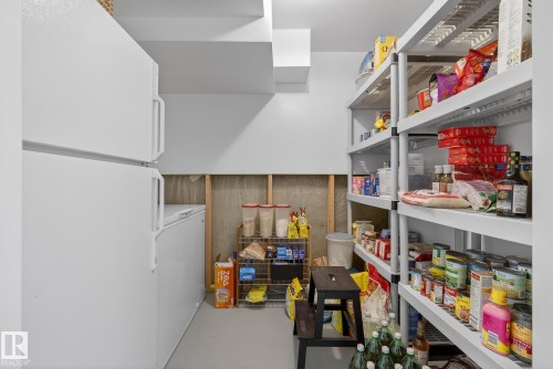 This space features a white refrigerator and a white chest freezer, providing substantial storage capacity - 17204 113 Street, Edmonton, AB - Indoor