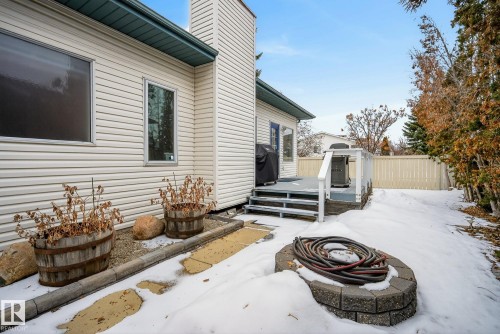 The property features a private deck with white railings, a light-colored privacy fence, and mature trees along the property line - 17204 113 Street, Edmonton, AB - Outdoor