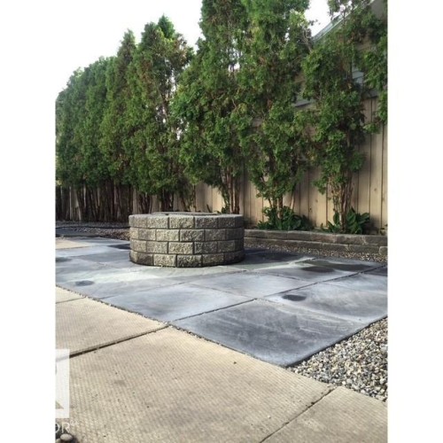 The property features a stone fire pit, a paved patio area, and a gravel border - 17204 113 Street, Edmonton, AB - Outdoor