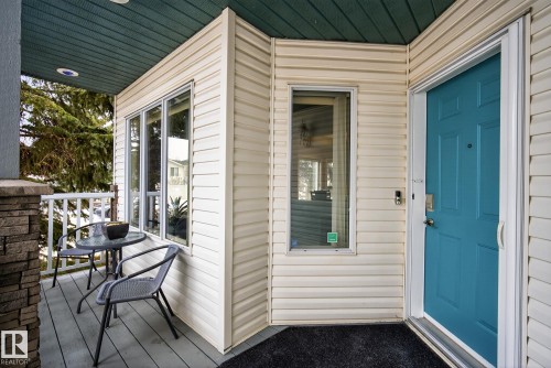 The property features a welcoming entrance with a vibrant blue door, white siding, and a covered porch - 17204 113 Street, Edmonton, AB - Outdoor With Deck Patio Veranda With Exterior