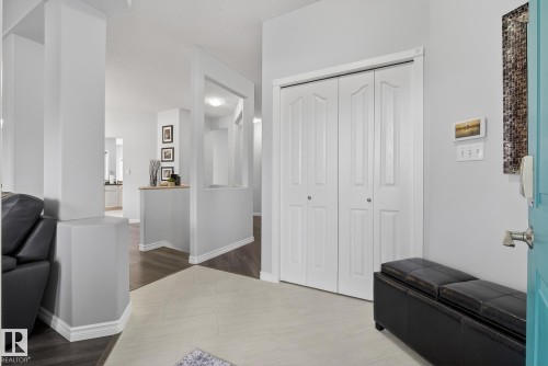 The entryway features light-colored floor tiles, a white bifold closet, and a light blue door - 17204 113 Street, Edmonton, AB - Indoor