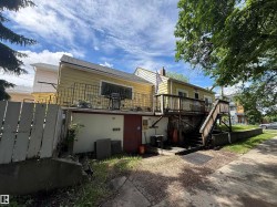 Yellow exterior siding with a dark asphalt shingle roof - 