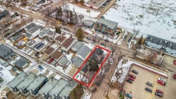 Aerial view of the property, highlighted in red, situated within a neighborhood featuring a mix of residential structures and commercial lots - 