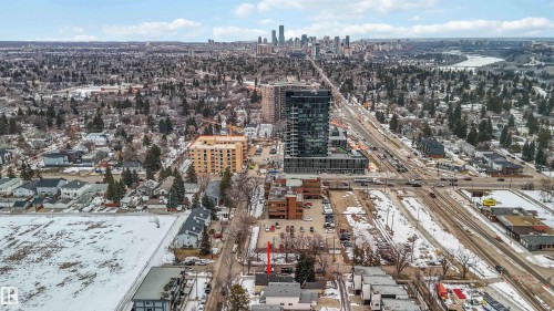 Aerial view of the property, showcasing its location within an established area with mature trees and proximity to urban infrastructure, including roadways and other structures - 10186 143 Street, Edmonton, AB - Outdoor With View