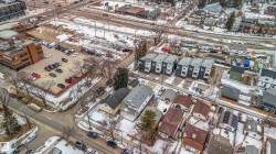 Aerial view showcasing a residential area with various property styles, including detached homes and multi-unit buildings - 