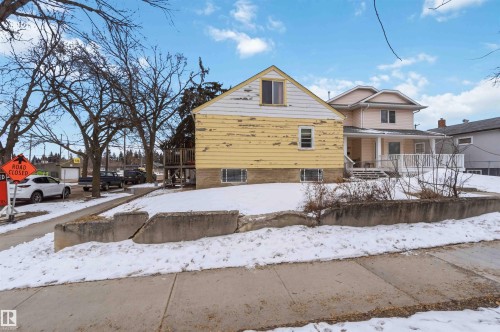 The property features a yellow exterior with white trim and a gabled roof - 10186 143 Street, Edmonton, AB - Outdoor