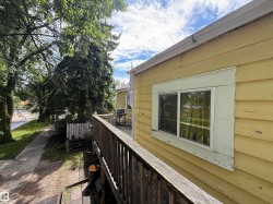 Exterior siding with a single-pane window and wood railing - 
